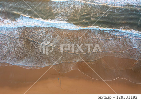 Gentle ocean waves washing onto sandy shoreline at Gentle ocean waves washing onto sandy shoreline at 129331192