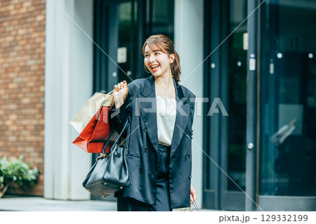 買い物袋を持った若い女性 129332199