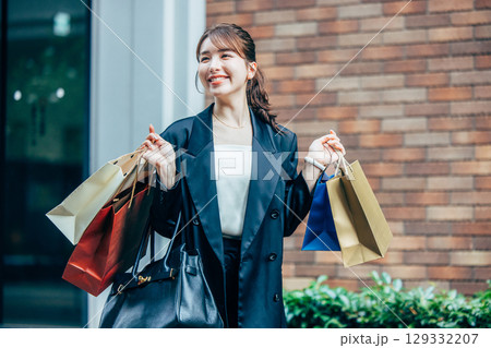 買い物袋を持った若い女性 129332207