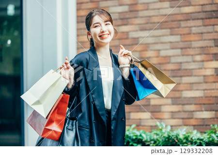 買い物袋を持った若い女性 129332208