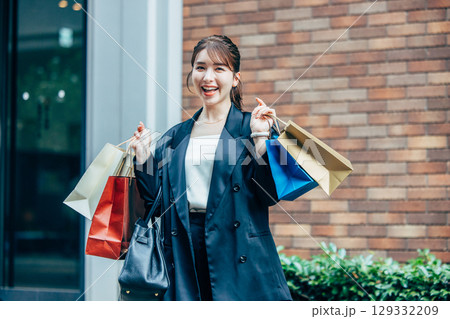 買い物袋を持った若い女性 129332209