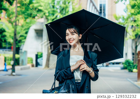 傘をさすビジネスウーマン 129332232
