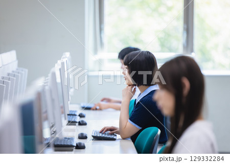 教室でパソコンを使って授業を受ける大学生 129332284