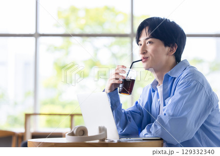 冷たい飲み物を飲む男性 129332340