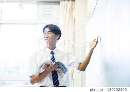 黒板の前で発表する男子中学生 129332806
