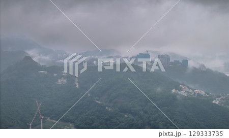 Aug 5 2025 Cityscape Over Green Hills During Misty Weather Offering a Serene Urban View 129333735