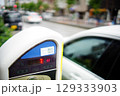 残り7分を示す路上パーキングメーターと駐車中の車 129333903