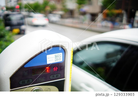 残り7分を示す路上パーキングメーターと駐車中の車 129333903
