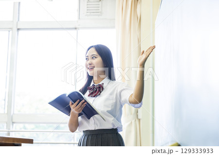 黒板の前で発表する女子高生 黒板の前で発表する女子高生 129333933