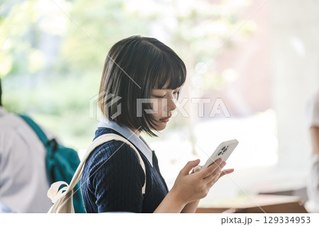 校内でスマートフォンを使う女子大学生 校内でスマートフォンを使う女子大学生 129334953