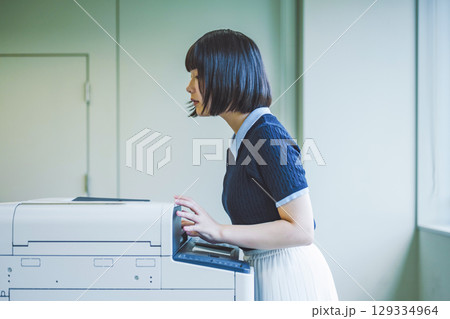 コピー機を操作する女性 129334964