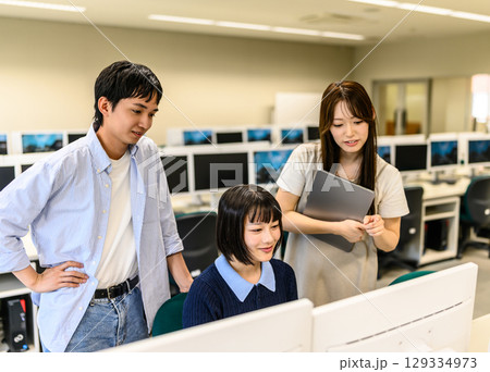 　ICTルームで生徒を指導する男女学生 129334973
