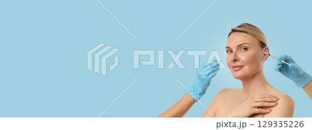 A woman smiles while undergoing a cosmetic procedure in a clinic A woman smiles while undergoing a cosmetic procedure in a clinic 129335226