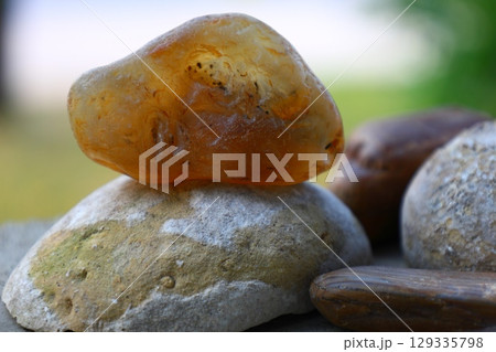 raw amber stone on rocks 129335798