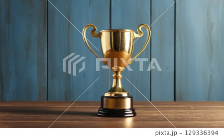 Golden Trophy on Wooden Table with Blue Wooden Background 129336394