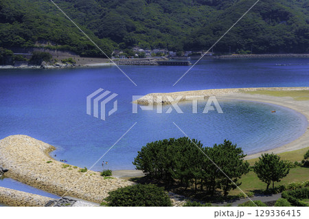 半月型の砂浜と青い海が美しいムーンビーチ井野浦の夏景色 129336415