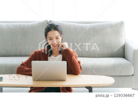 リビングでパソコンを操作する女性 リビングでパソコンを操作する女性 129336667