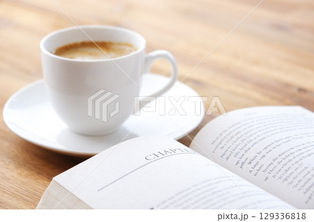 コーヒーを飲みながら、のんびりペーパーバック（洋書）を読んでいるイメージ 129336818
