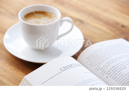 コーヒーを飲みながら、のんびりペーパーバック(洋書)を読んでいるイメージ コーヒーを飲みながら、のんびりペーパーバック(洋書)を読んでいるイメージ 129336820