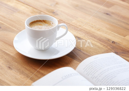 コーヒーを飲みながら、のんびりペーパーバック(洋書)を読んでいるイメージ コーヒーを飲みながら、のんびりペーパーバック(洋書)を読んでいるイメージ 129336822