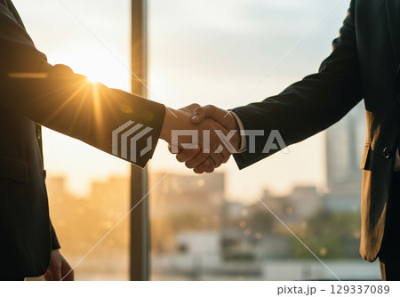 Businessmen shaking hands at sunset, deal concept 129337089