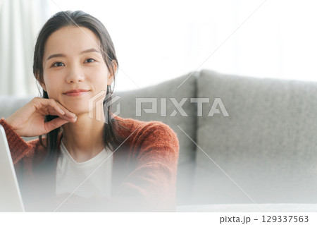 リビングでパソコンを操作する女性 リビングでパソコンを操作する女性 129337563