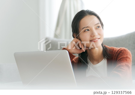 リビングでパソコンを操作する女性 129337566