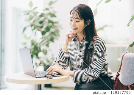 カフェでパソコンを使う女性 カフェでパソコンを使う女性 129337796