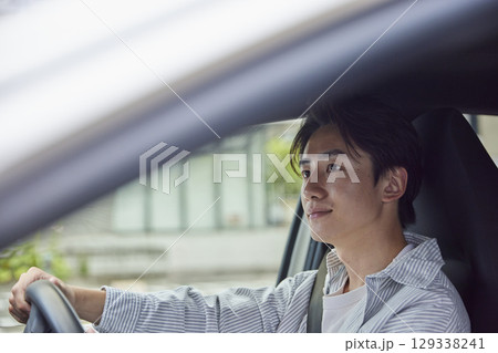 運転席で前方を見ながらドライブする若い日本人男性の横顔 運転席で前方を見ながらドライブする若い日本人男性の横顔 129338241
