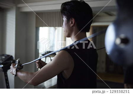 フィットネスジムで筋力トレーニングを行うスポーツウェアを着た若い日本人男性 129338251