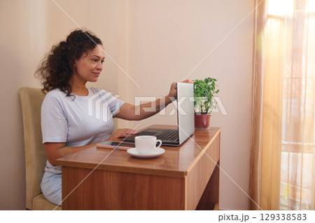 Freelancer Working From Home With a Laptop in a Cozy Interior Setting 129338583