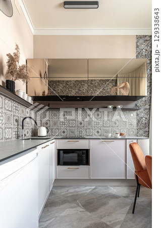 Modern Kitchen with Patterned Tiles and Elegant Dining Area 129338643