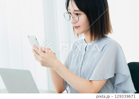 オフィスでスマホを見るビジネスウーマン 129339671