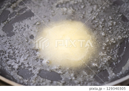 フライパンにマーガリンを入れて温めたところ　(写真素材) 129340305