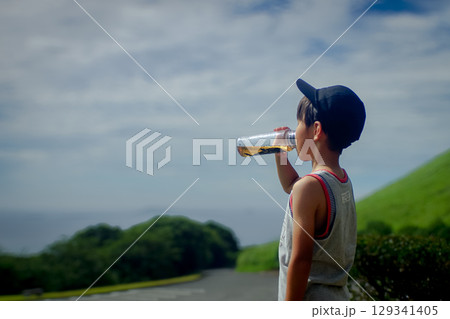 ＜素材＞公園遊び中に水筒のお茶を飲む少年 129341405