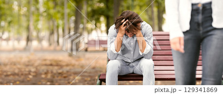 Break Up. Girlfriend Leaving Desperate Boyfriend Sitting On Bench In Park Outdoor Quitting Relationship. Selective Focus, Cropped 129341869