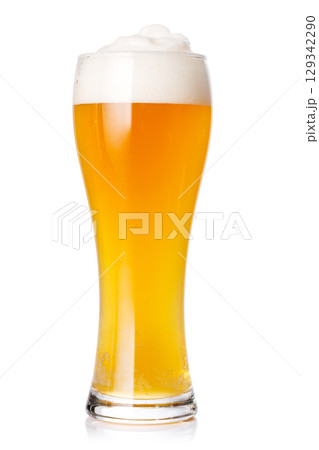 A glass of beer with a golden hue and frothy head, isolated on a clean white background 129342290