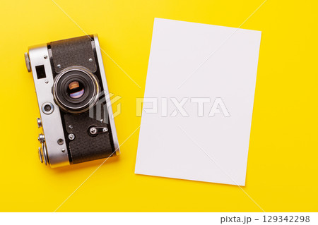 Travel-themed flat lay with blank photo card, camera 129342298