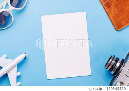 Travel-themed flat lay with blank photo card, camera, toy airplane 129342330