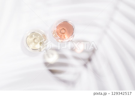 Two wine glasses filled with rose and white wine 129342517