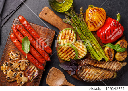 Assorted grilled vegetables including bell peppers, zucchini, eggplant, and sausages 129342721