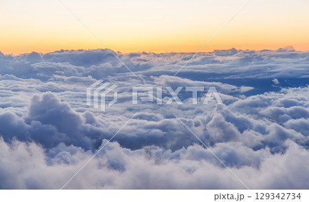 Sunset above the clouds with warm colors and soft light Sunset above the clouds with warm colors and soft light 129342734