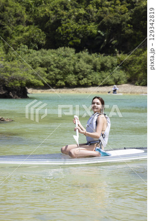 SUPを楽しむかわいい女性 SUPを楽しむかわいい女性 129342819