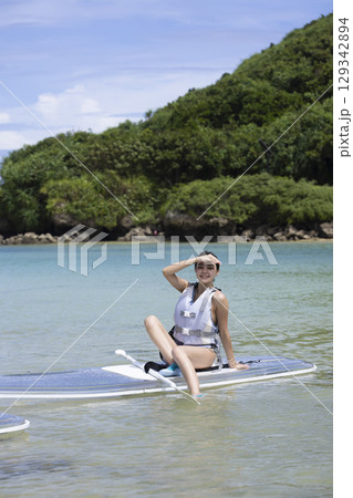SUPを楽しむかわいい女性 129342894