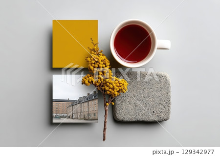 Moodboard with textured swatches, a cup of tea, and a branch of yellow flowers 129342977