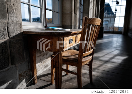 Elegant reading table with a wooden chair in a well-lit interior space Elegant reading table with a wooden chair in a well-lit interior space 129342982