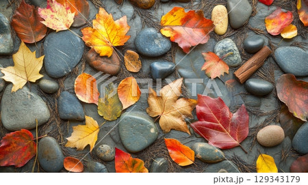 Vibrant autumn leaves in shades of red, orange, and yellow lay atop smooth pebbles, creating a beautiful natural display. Vibrant autumn leaves in shades of red, orange, and yellow lay atop smooth pebbles, creating a beautiful natural display. 129343179