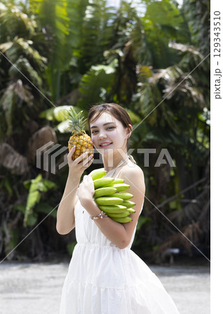 パイナップルとバナナを持つ女性 129343510