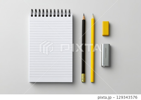 Simple workspace setup with notebook, pencils, and eraser against a clean background 129343576