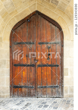Wooden Arched Door with Rustic Iron Hinges and Brick Surround Wooden Arched Door with Rustic Iron Hinges and Brick Surround 129343690